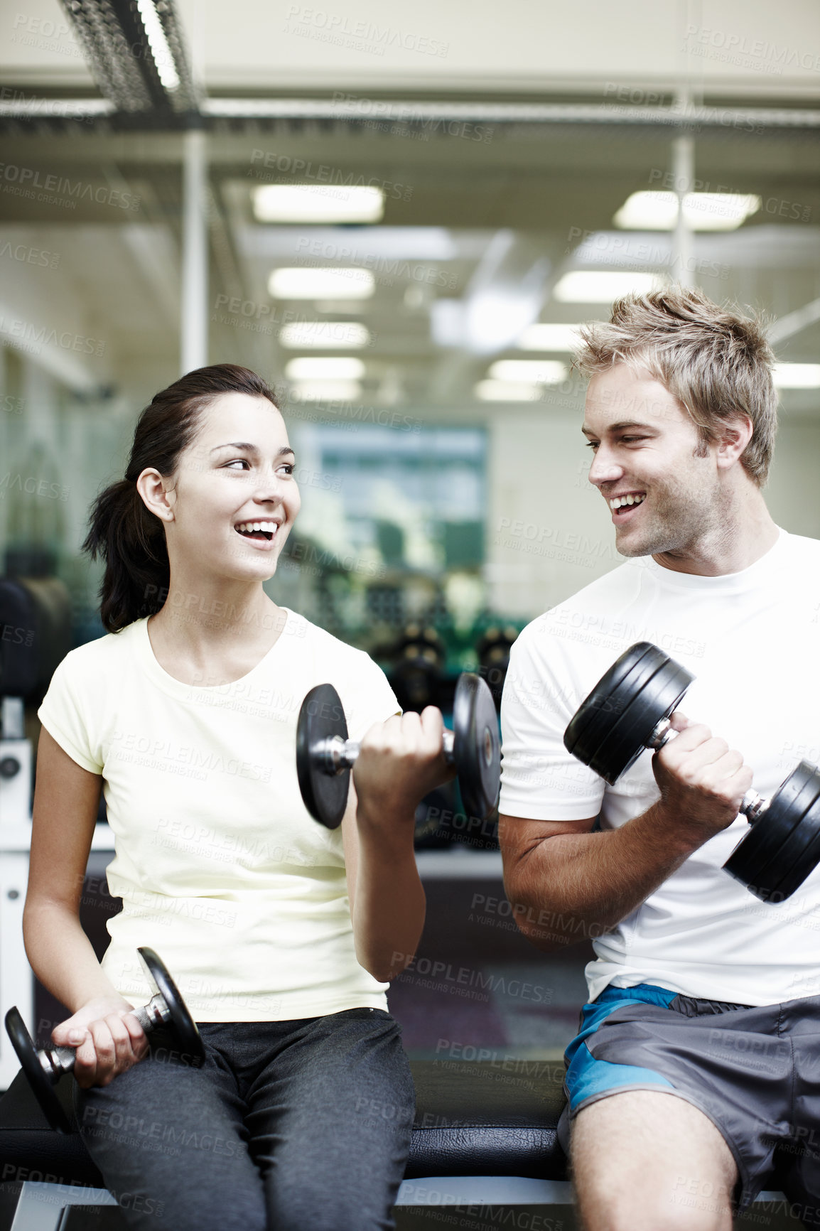 Buy stock photo Happy, couple and training with weights in gym for bodybuilding, fitness and workout together. Man, woman and smile with equipment in health club for strength exercise, teamwork or support in morning