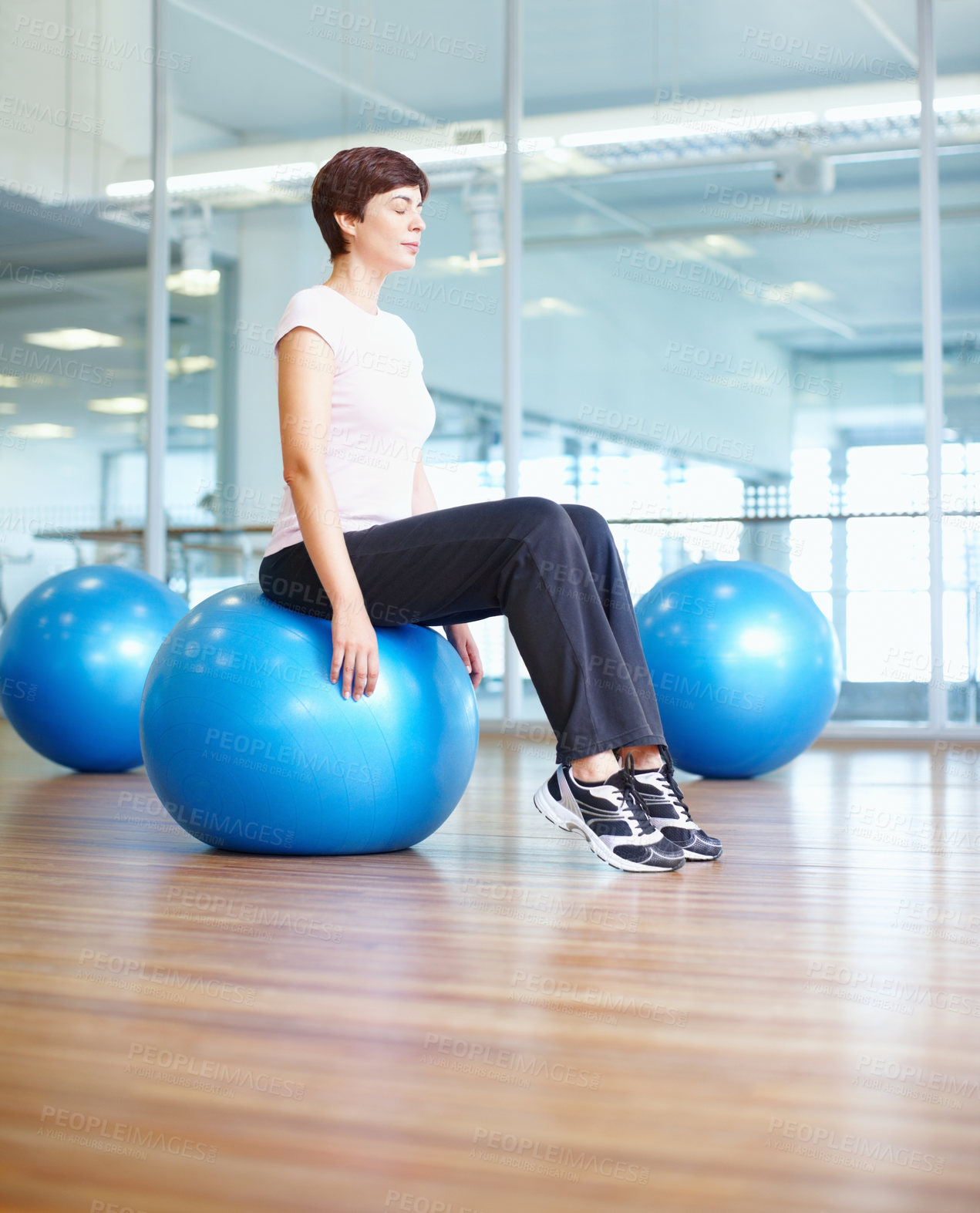 Buy stock photo Full length of a fit woman sitting on pilates ball and relaxing