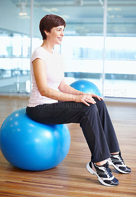 Buy stock photo Full length of woman sitting on gymnastic ball and smiling