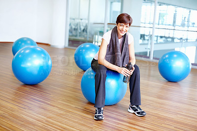 Buy stock photo Portrait of fit smiling woman sitting on pilates ball during her training session