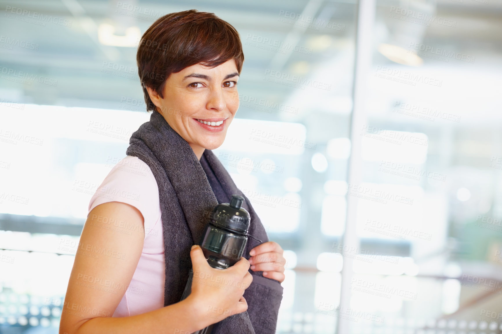 Buy stock photo Fitness, woman and portrait with towel in gym for exercise break, water bottle or smile for workout. Mature athlete, person and happy in sports center for health progress, wellness and healthy body