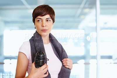 Buy stock photo Woman with towel and water bottle looking away during a break from workout