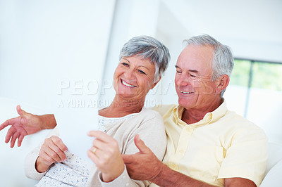 Buy stock photo Happy mature couple smiling while discussing domestic bills