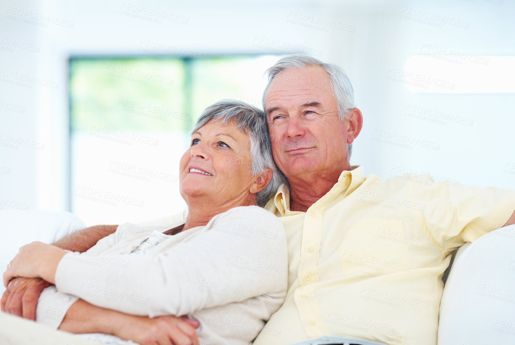 Buy stock photo Old couple, relax and hug in home, security and love in marriage connection on couch. Elderly people, embrace and commitment to relationship in retirement, bonding and support for comfort on sofa