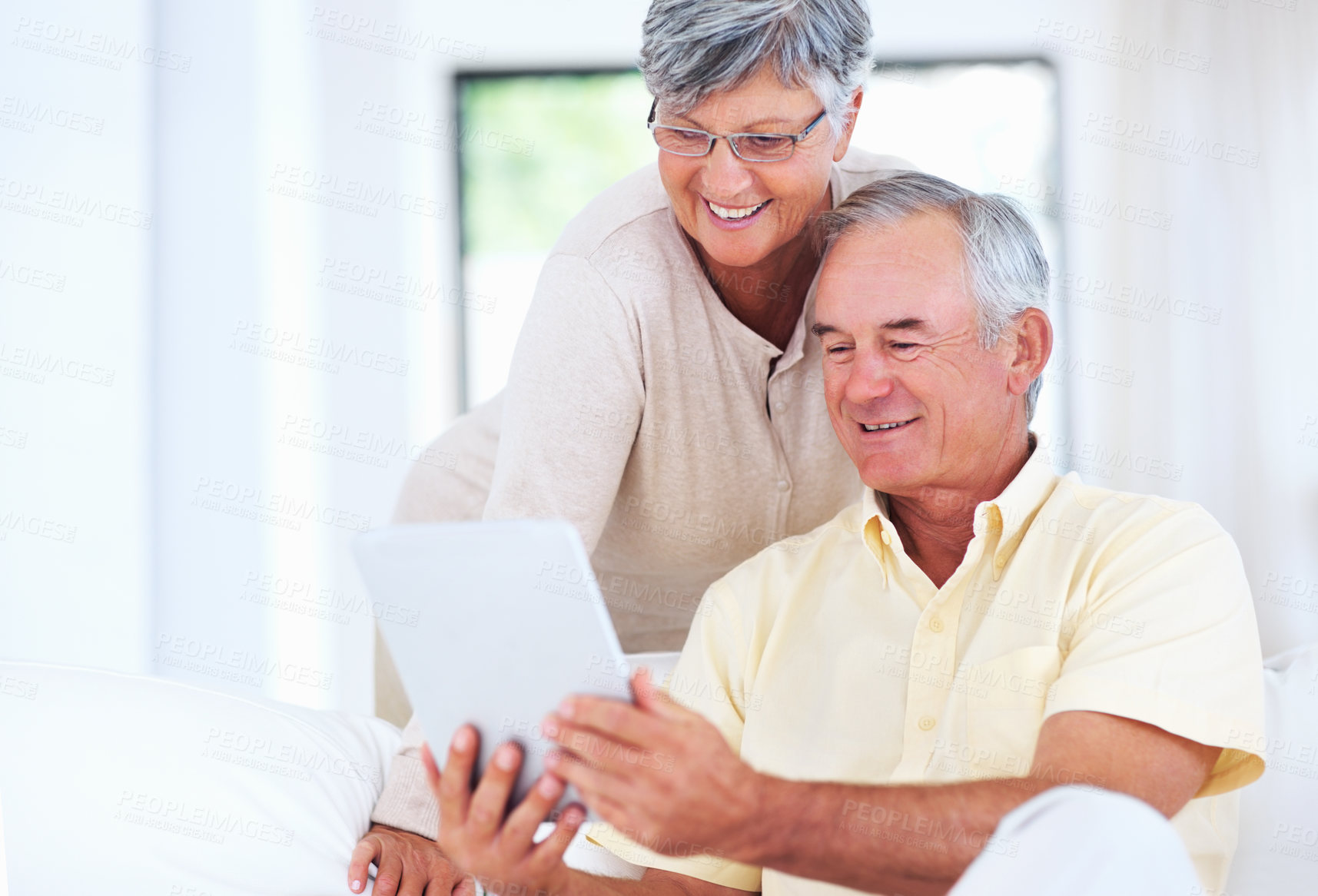 Buy stock photo Senior couple, tablet and home for blog article, surfing social media and internet for communication. Elderly people, relax and together for bonding in living room, reading funny ebook and streaming