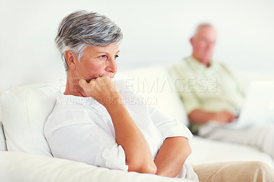 Buy stock photo Portrait of beautiful mature woman thinking with man working in background at home