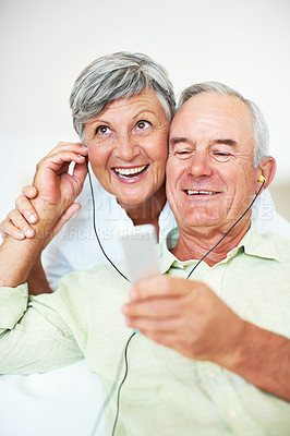 Buy stock photo Sofa, senior couple and listening with earphones for music, hearing and connection for bonding together. Home, man and happy woman in retirement with audio track, blues and classic pop for relaxation