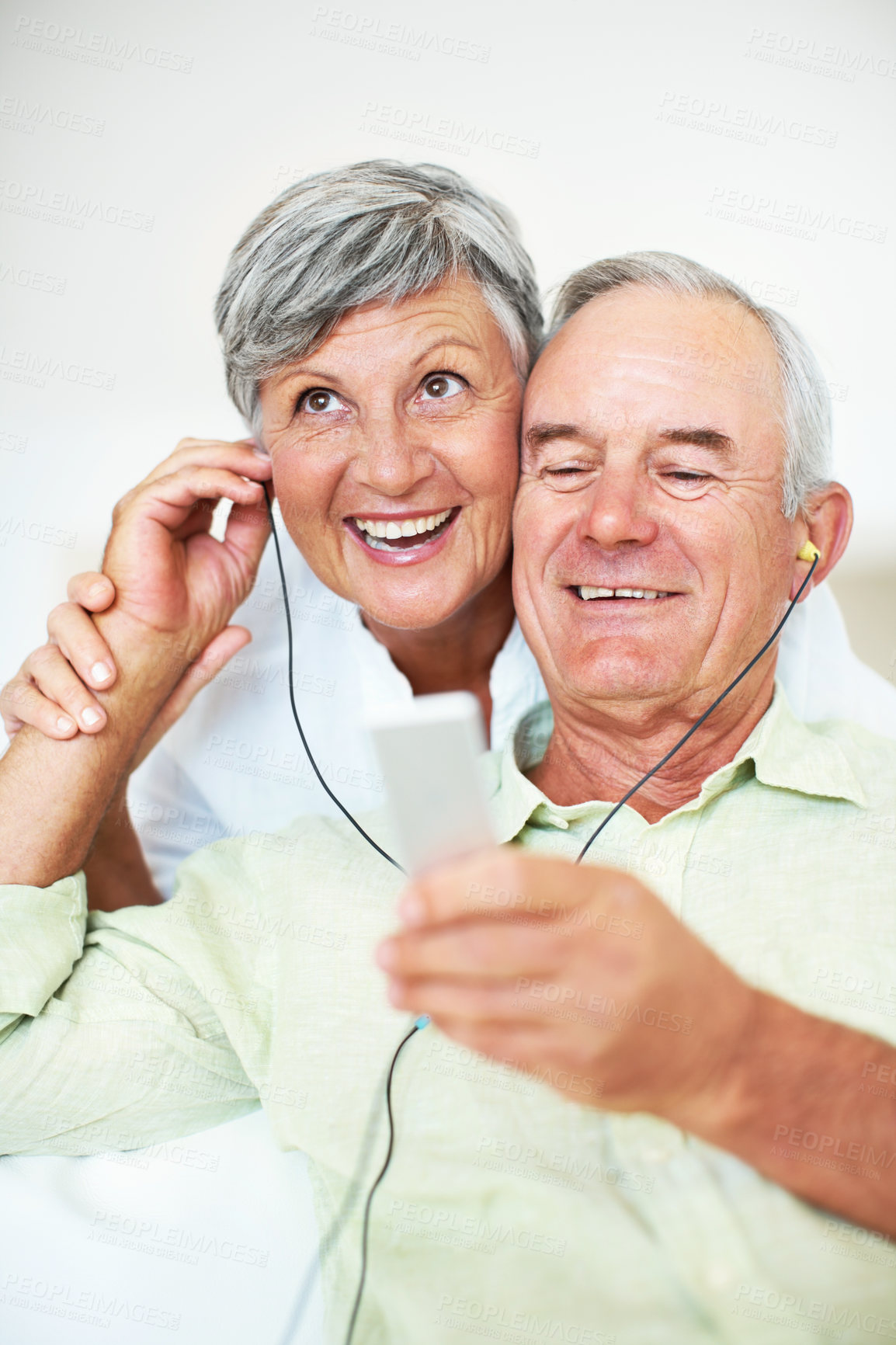 Buy stock photo Sofa, senior couple and listening with earphones for music, hearing and connection for bonding together. Home, man and happy woman in retirement with audio track, blues and classic pop for relaxation