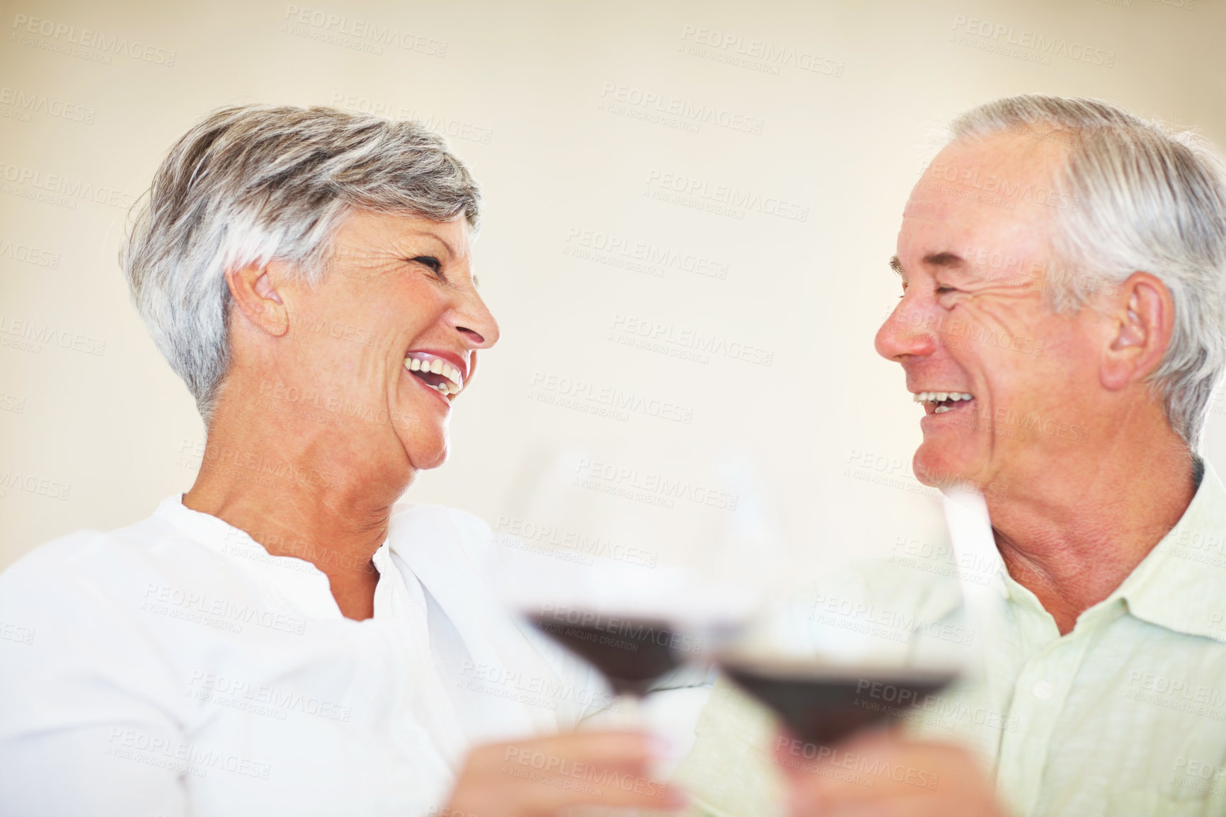 Buy stock photo Senior couple, laughing and toast in home, marriage anniversary and growth in partnership. Elderly people, romance and cheers with alcohol glasses for love celebration, milestone and bonding on date