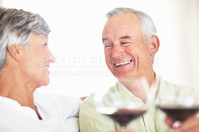 Buy stock photo Smiling mature man and woman toasting with red wine at home