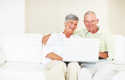 Buy stock photo Sofa, senior couple and laughing with laptop for movie, comedy film and entertainment in retirement. Happy people, woman and man with digital for streaming series, online video and bonding at home