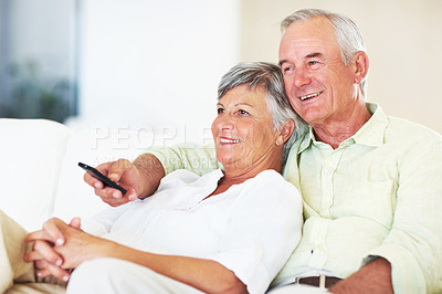 Buy stock photo Relaxed mature couple watching television while sitting on couch
