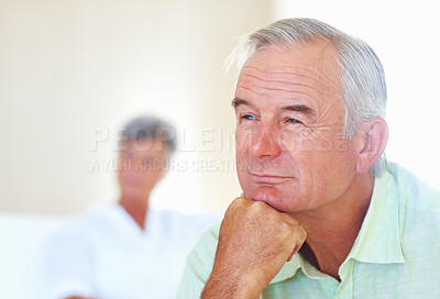 Buy stock photo Closeup of thoughtful mature man thinking at home with woman in background