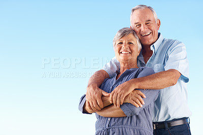 Buy stock photo Portrait of cheerful mature man embracing beautiful woman against blue sky