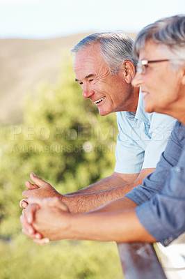 Buy stock photo Happy mature couple smiling while enjoying view from balcony