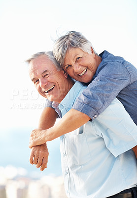 Buy stock photo Portrait of smiling mature man giving piggyback ride to woman outdoors with arms outstretched