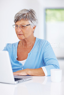 Buy stock photo Confident mature woman using laptop at home
