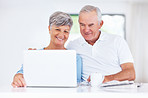 Mature couple using laptop at home