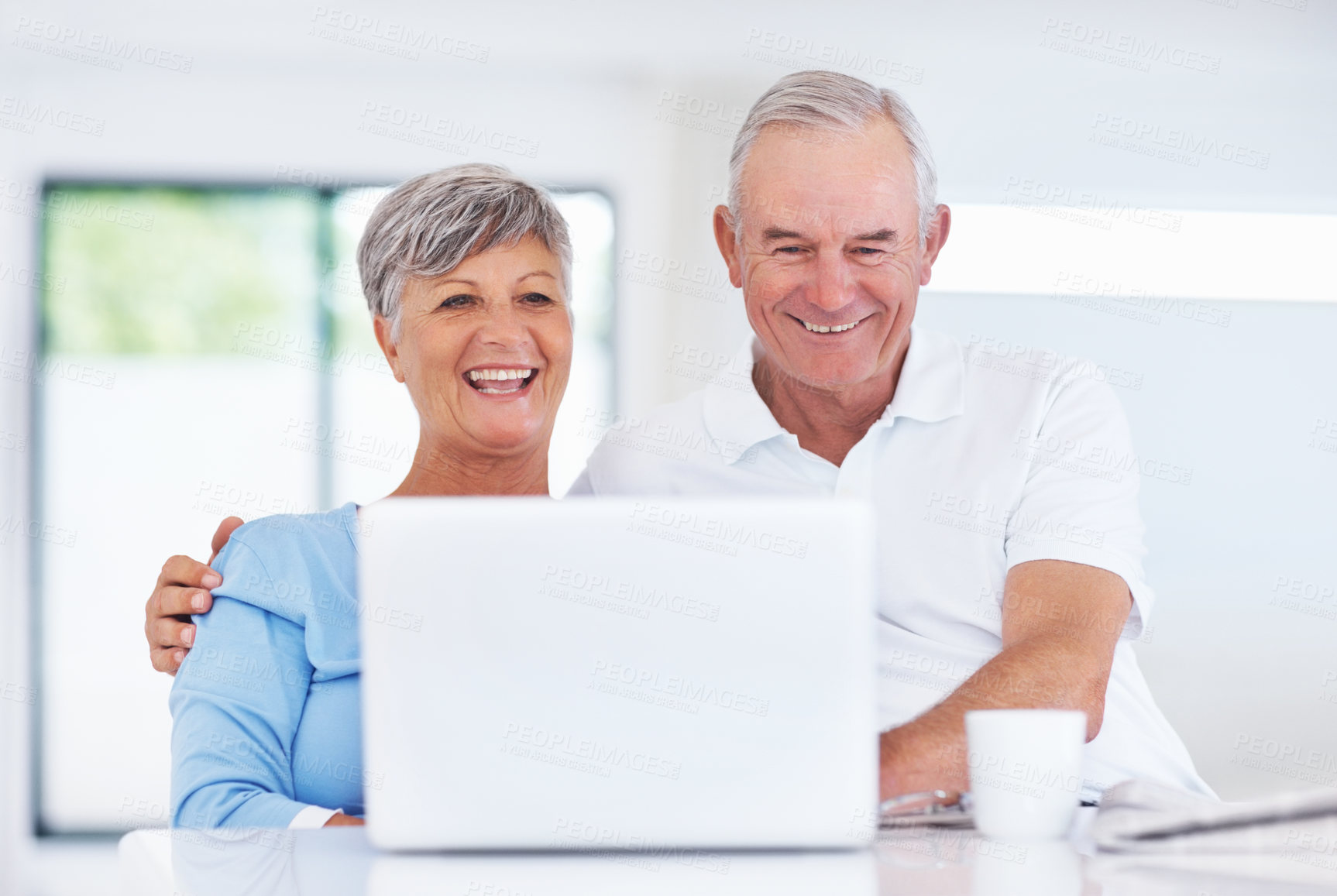 Buy stock photo Senior man, woman and laugh with laptop, relax and watch live stream for funny video on web in home. Happy couple, computer and elderly people in kitchen with comic memory, movie and story in house