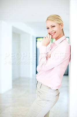 Buy stock photo An attractive young businesswoman leaning against a wall in an indoor setting