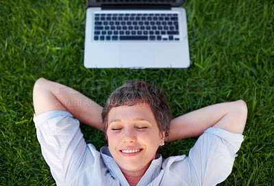 Buy stock photo Top view relaxed mature woman with laptop smiling while lying on grass