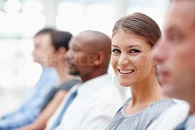 Buy stock photo Beautiful business executive smiles at you while attending a seminar