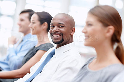 Buy stock photo Handsome African American businessman smiles at you while attending a conference