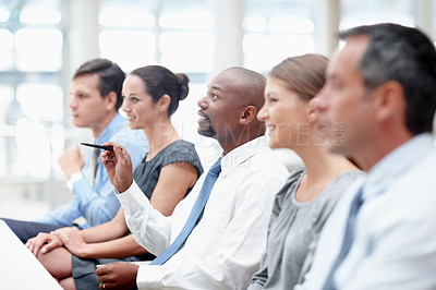 Buy stock photo Interested team of executives sit in a meeting together