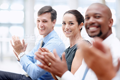 Buy stock photo Happy young female executive applauds with her colleagues at a seminar