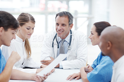 Buy stock photo Group of healthcare professionals sitting around a boardroom table having a discussion 