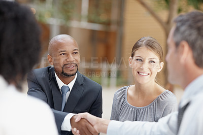 Buy stock photo Business people, handshake and meeting with team for agreement, deal or collaboration at office. Businessmen, colleagues or employees shaking hands for b2b contract, thank you or mission at workplace