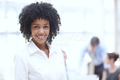 Buy stock photo A happy african woman standing in the office with her colleagues in the background