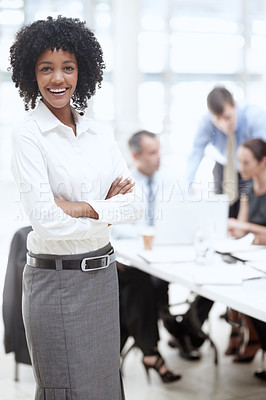 Buy stock photo A confident african woman standing in the office with her colleagues in the background