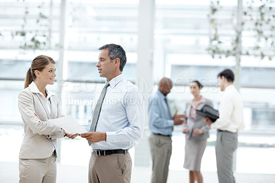 Buy stock photo Businesspeople having a discussion with their colleagues in the background