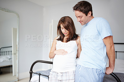 Buy stock photo Affection, pregnant and couple with smile, embrace and bonding in home, love and happy for unborn baby. House, man and woman in relationship, stomach and cheerful for parenthood and family in bedroom