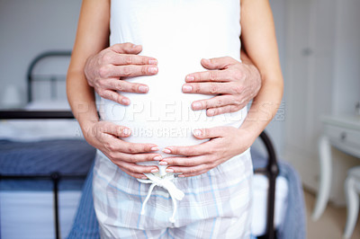 Buy stock photo Cropped image of expectant parents holding her baby bump