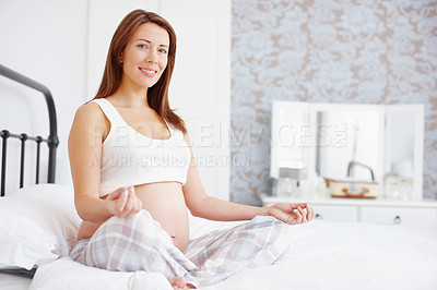 Buy stock photo Portrait of a beautiful pregnant woman sitting in the lotus position on her bed - Copyspace