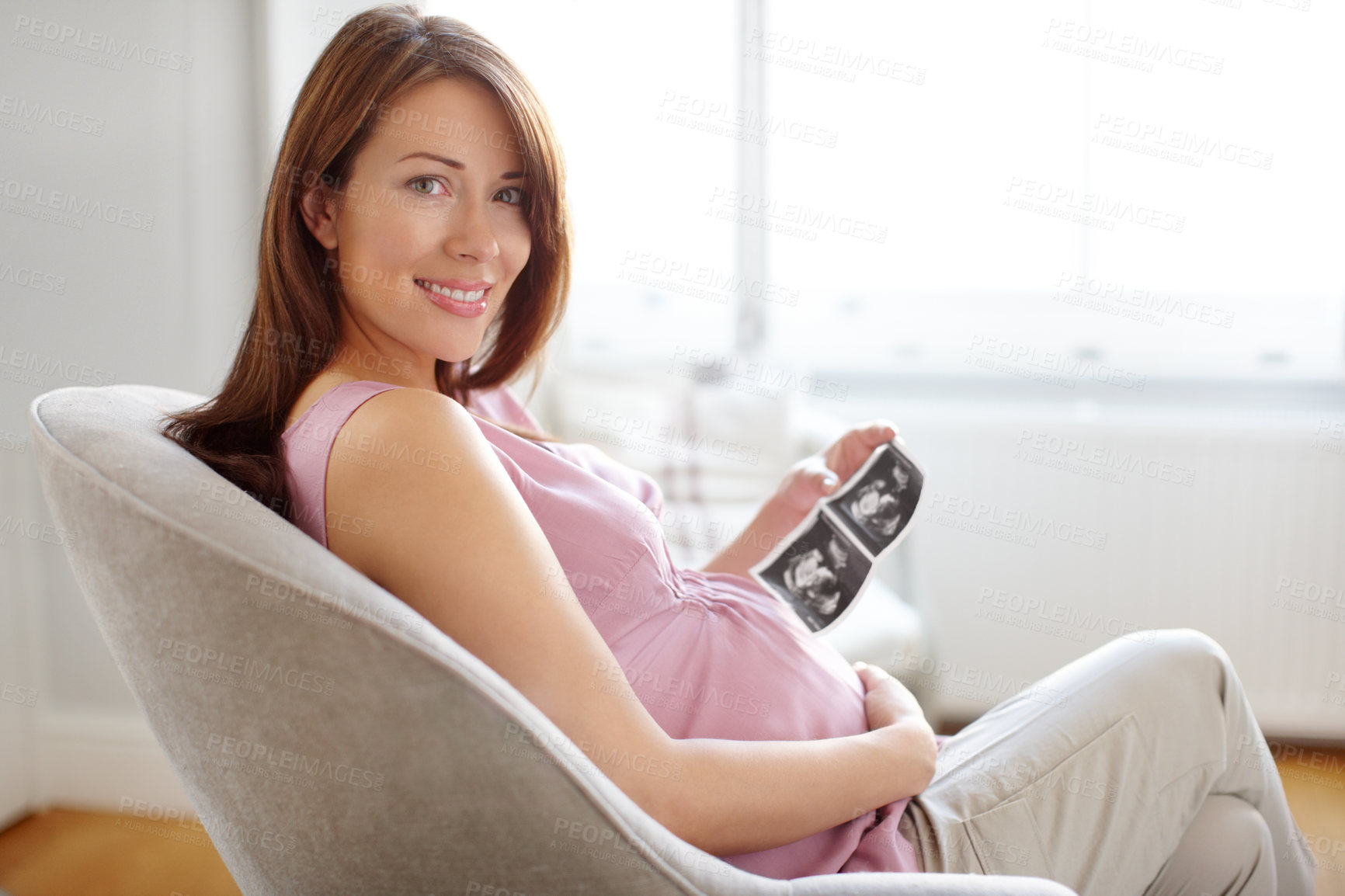 Buy stock photo Woman, home and happy for pregnancy with scan of baby for future, growth and infant. Female person, maternity and smile or satisfied on couch in living room with belly bump, ultrasound or development