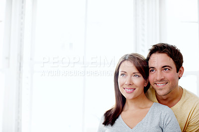 Buy stock photo Attractive young couple standing indoors together and looking away - Copyspace 