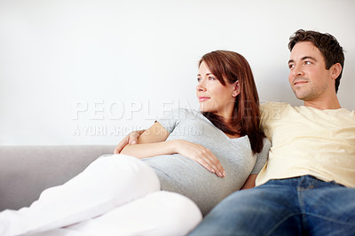 Buy stock photo Couple, home and smile for pregnancy on sofa in living room on maternity break, bonding or relax. People, love and happy in relationship at apartment for support, trust and care for future or growth