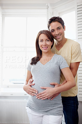 Buy stock photo Portrait of an expectant couple standing together at a window - Copyspace