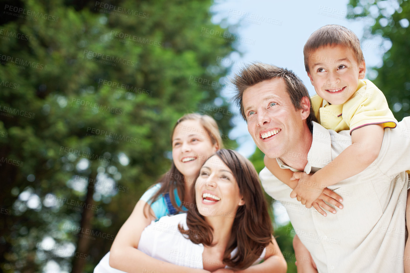 Buy stock photo Family, park and fun outdoor with piggy back, game and smile with mom, dad and kids together. Bonding, love and care with happy youth and hug in nature with trees, weekend and summer break in garden