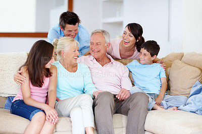 Buy stock photo A loving family laughing on a lounge sofa together