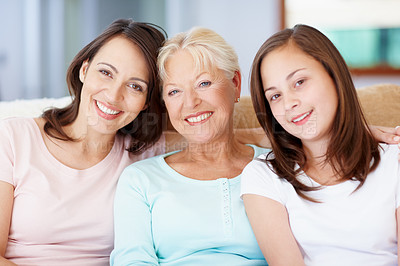 Buy stock photo Three generations of girls sitting together on the lounge sofa together and smiling