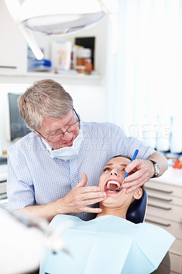 Buy stock photo Portrait of male dentist checking patient's teeth