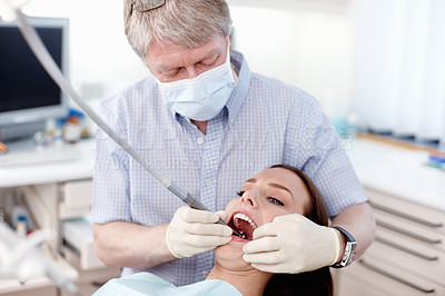 Buy stock photo Portrait of dentist inspecting patient's teeth in clinic