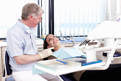 Buy stock photo Portrait of mature doctor speaking to his patient in clinic