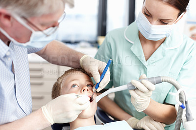 Buy stock photo Portrait of dentist operating young boy's teeth in clinic