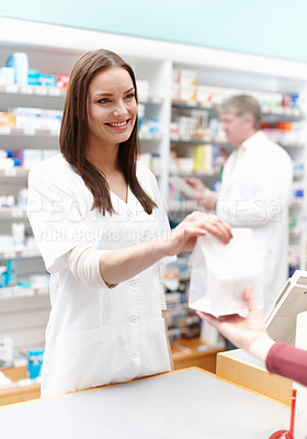 Buy stock photo Portrait of pharmacist handing over the package to customer at medical store