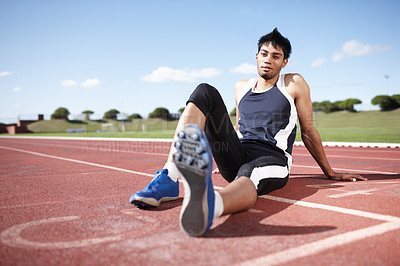 Buy stock photo A young athlete leaning back on a running track